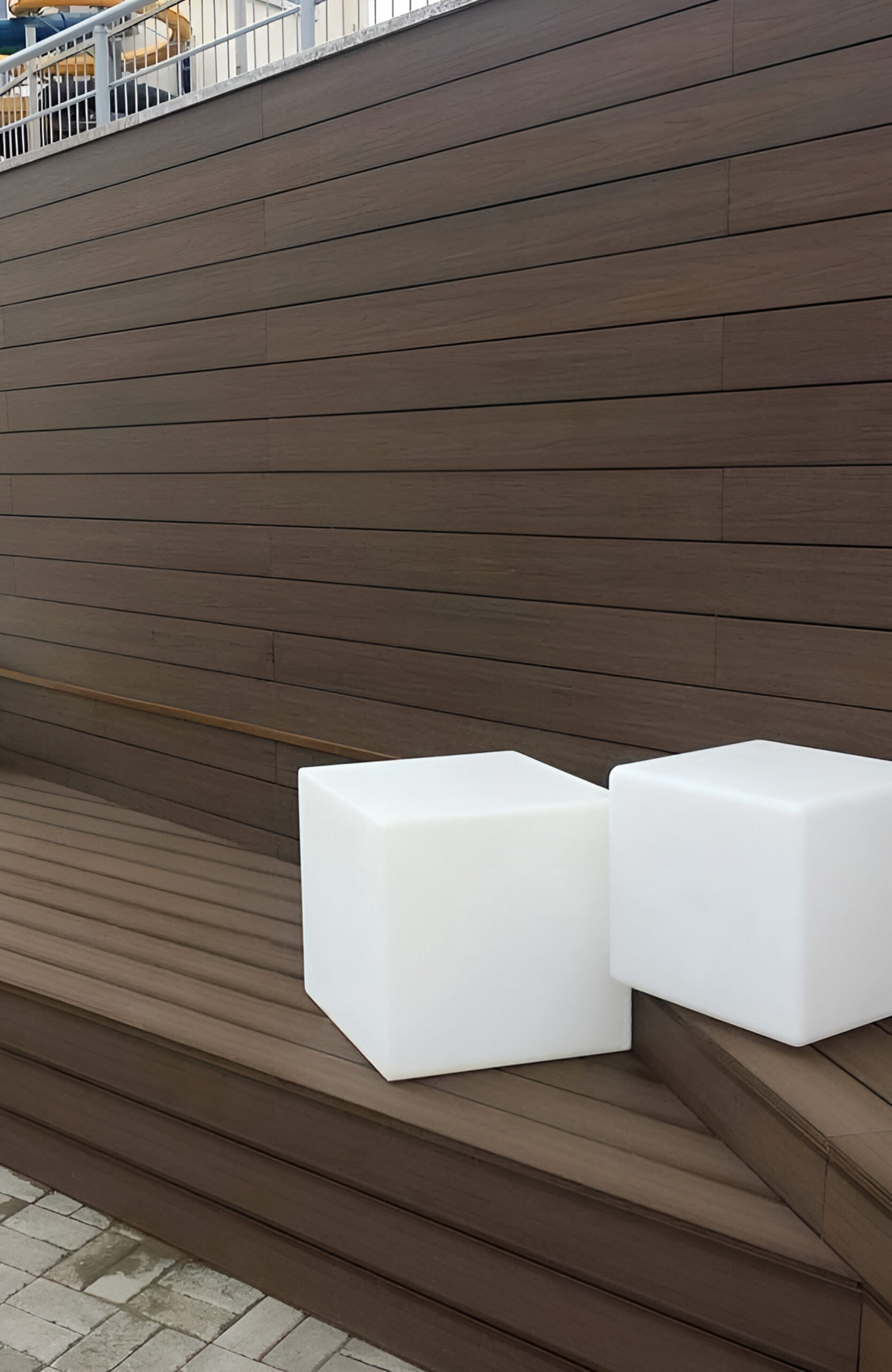 Close-up of brown composite wall cladding and built-in bench with modern cube lights