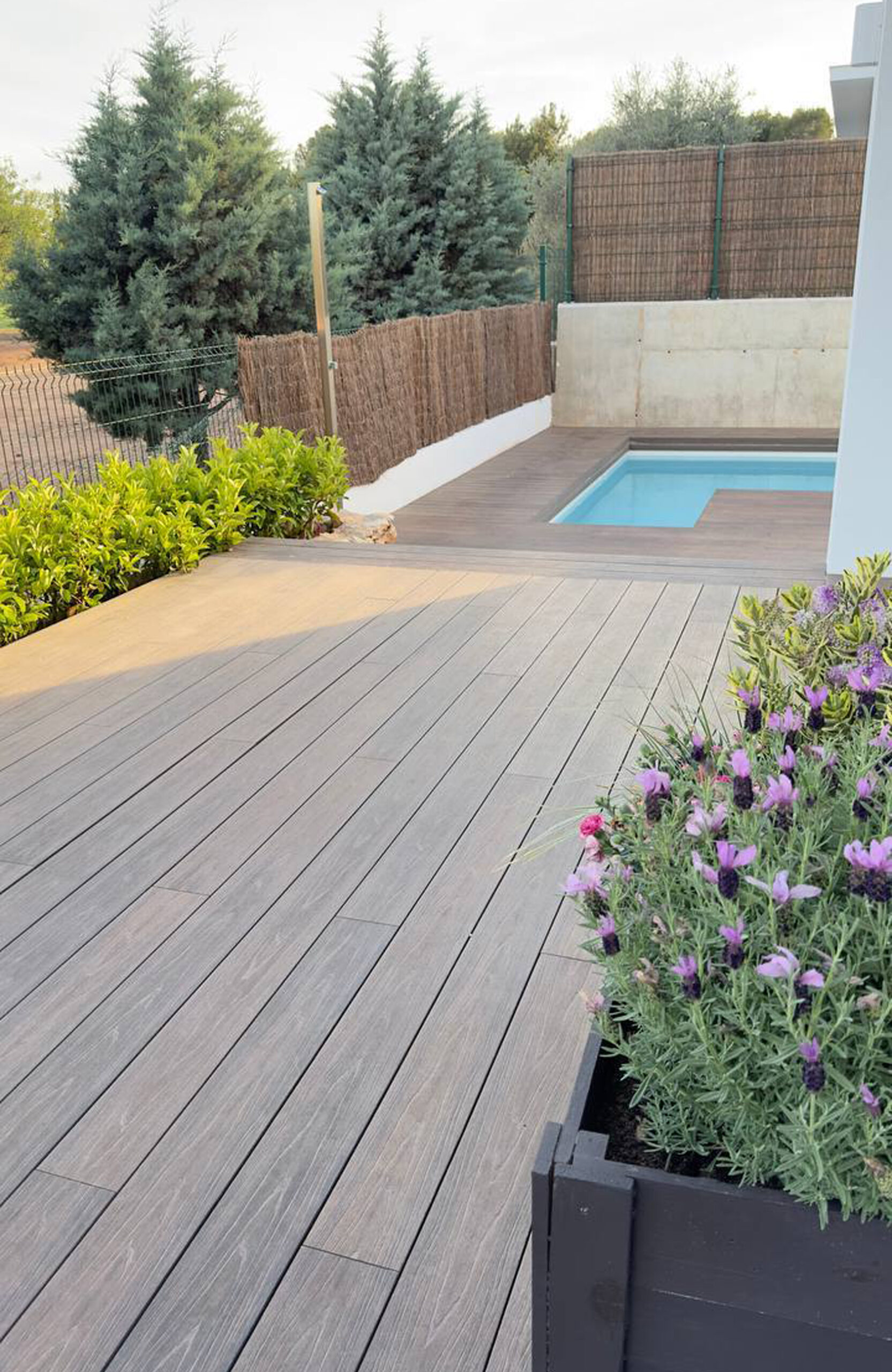 Spacious LEGRO walnut composite deck leading to a private swimming pool