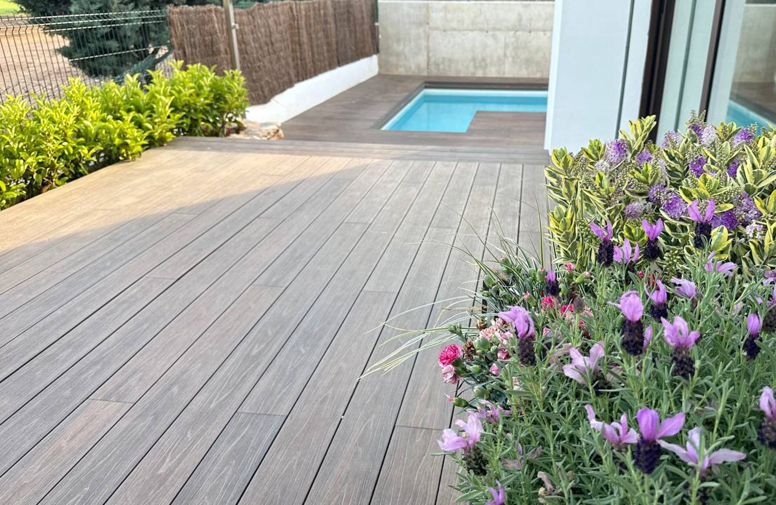 Spacious LEGRO walnut composite deck leading to a private swimming pool
