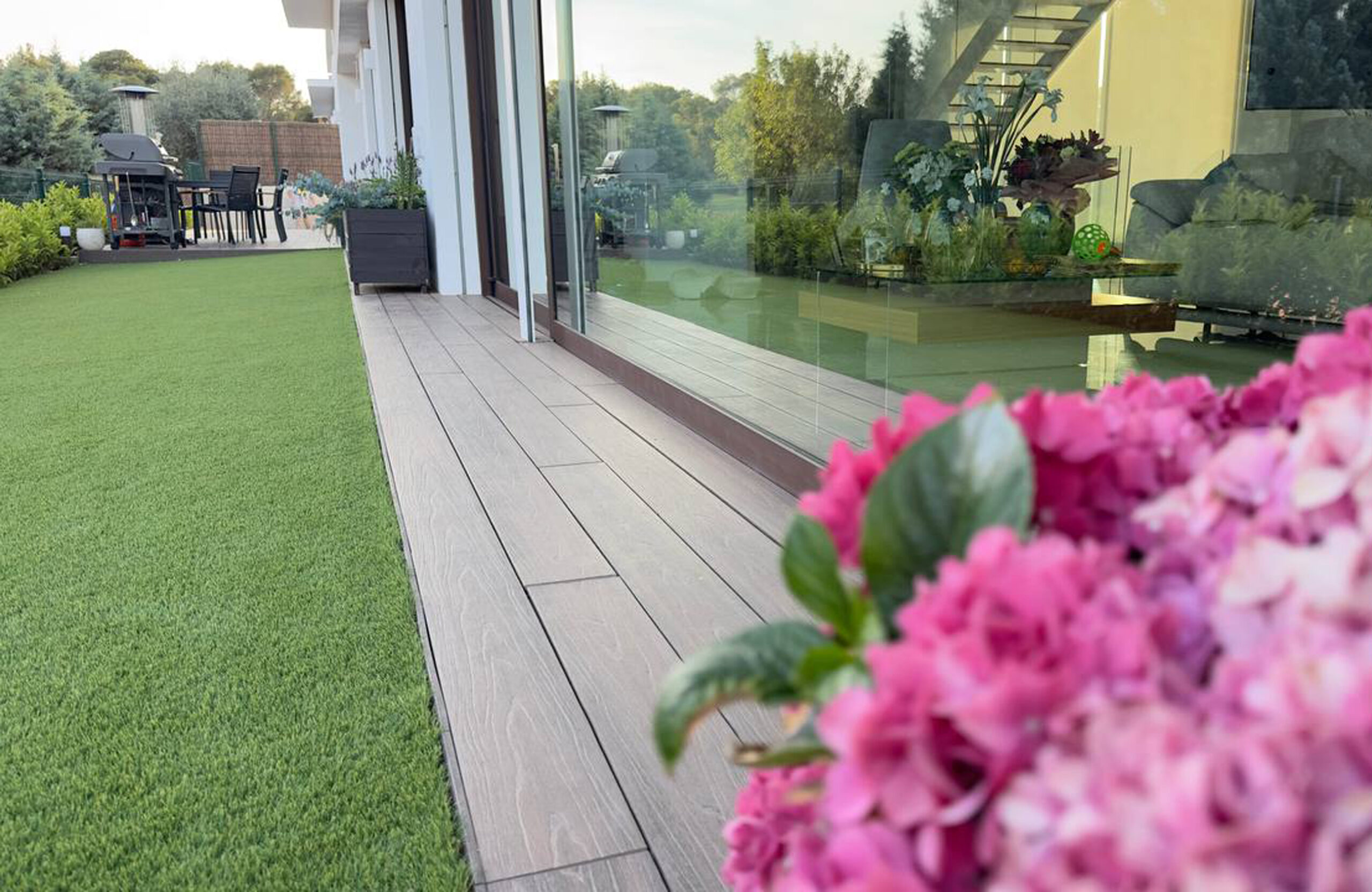 LEGRO walnut composite decking terrace with flowers and natural stone walls