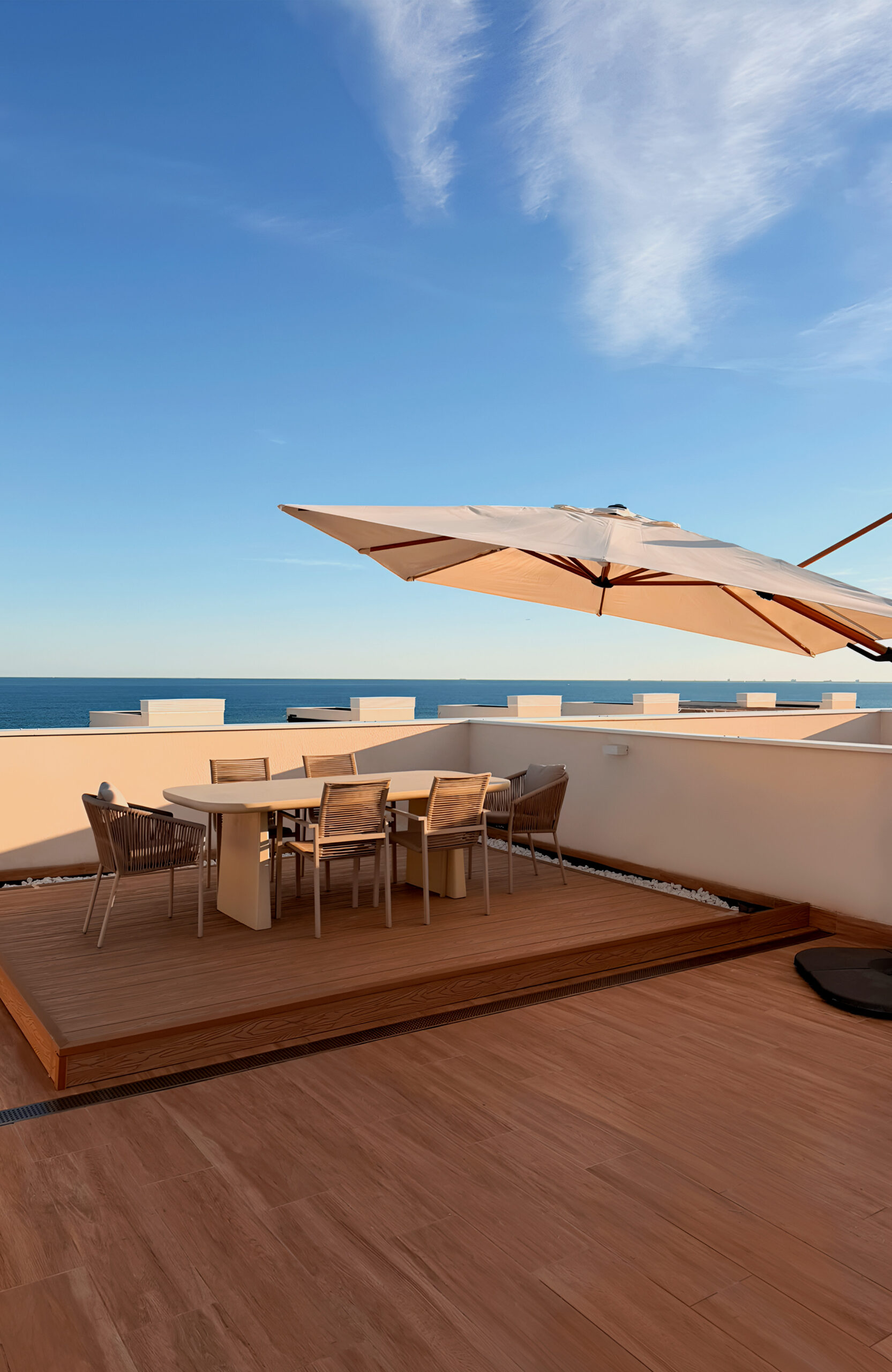 Dining area on the Copper Natural-colored open-air rooftop terrace with a view of the sea