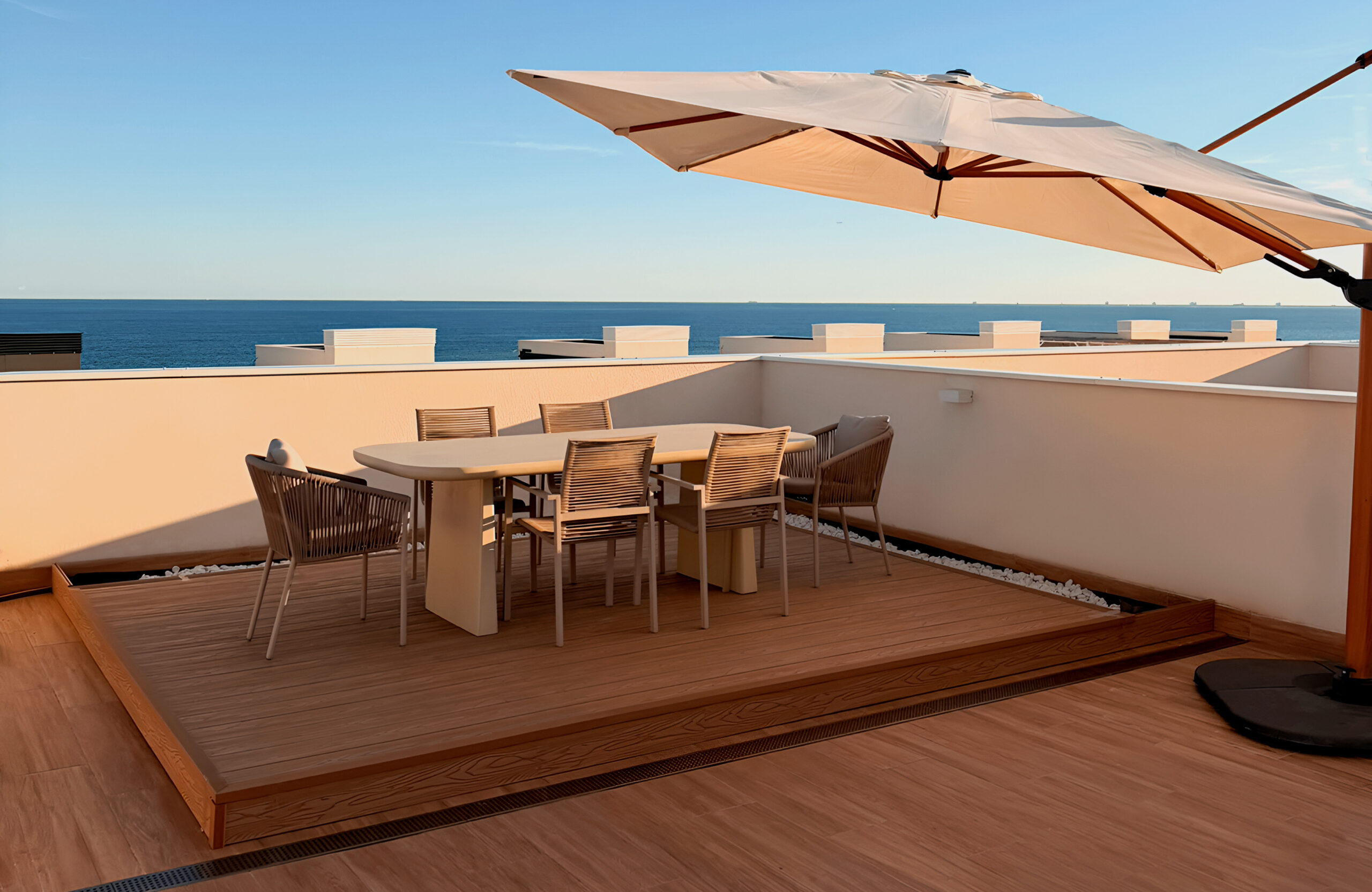 Dining area on the Copper Natural-colored open-air rooftop terrace with a view of the sea