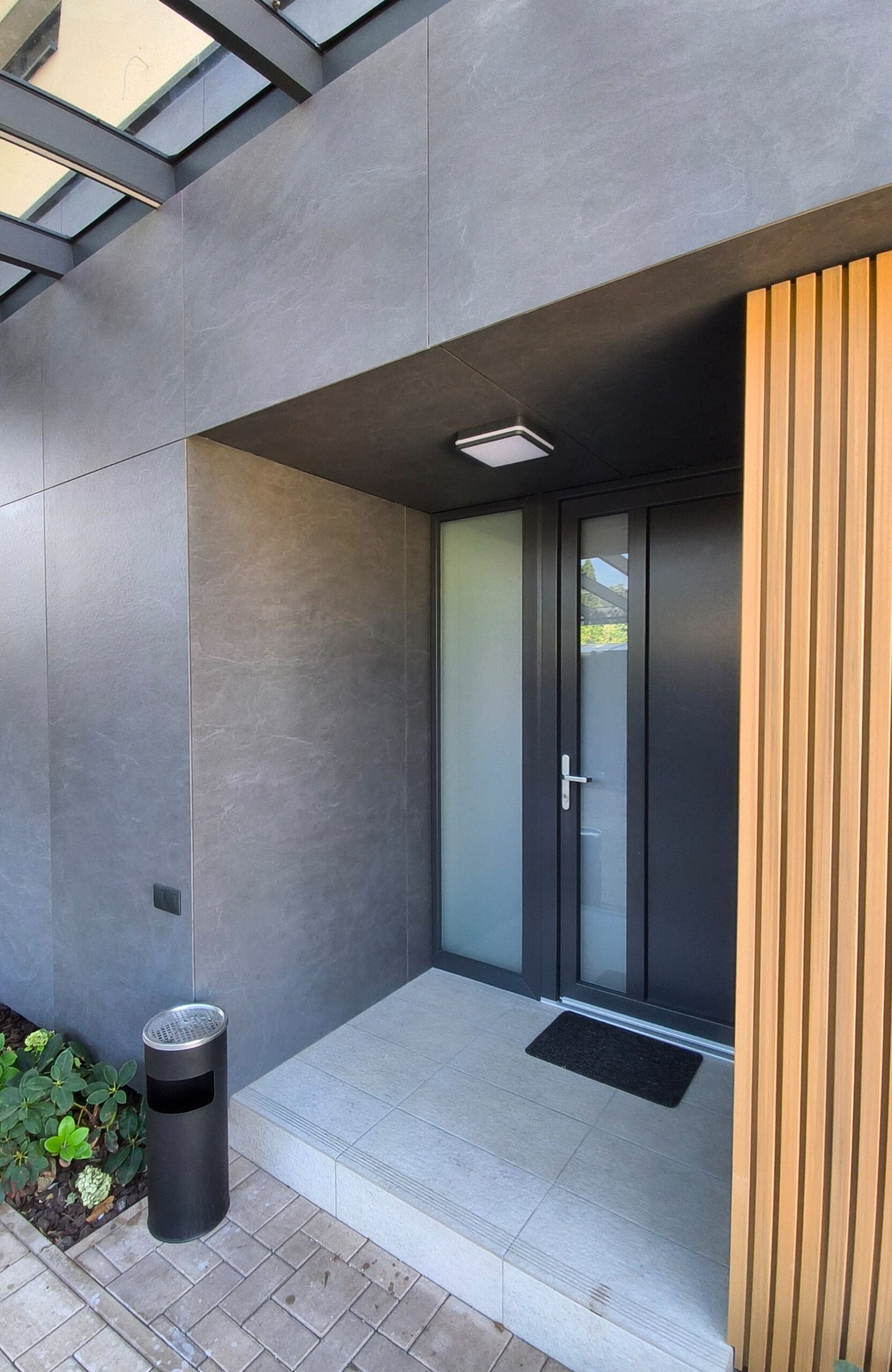 Contemporary house exterior with LEGRO FS15 Maple vertical facade boards and contrasting dark grey cladding